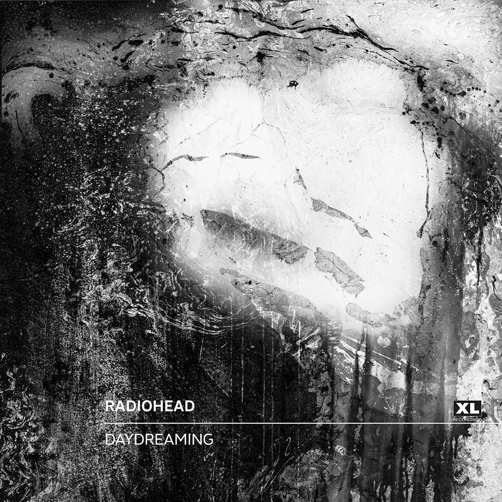 Distorted, abstract face-like shape emerging from a dark, textured background.