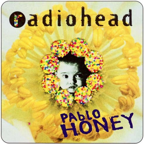 Album cover for Radiohead’s ’Pablo Honey’ featuring a baby’s face surrounded by colorful candy-like circles on a yellow flower background.