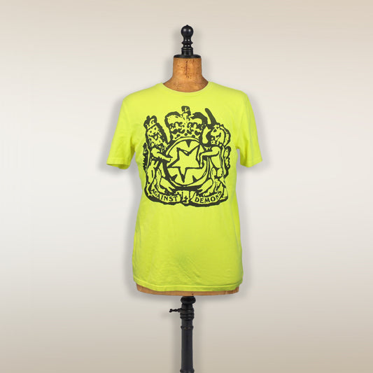 Bright neon yellow t-shirt with a black coat of arms design displayed on a mannequin torso.